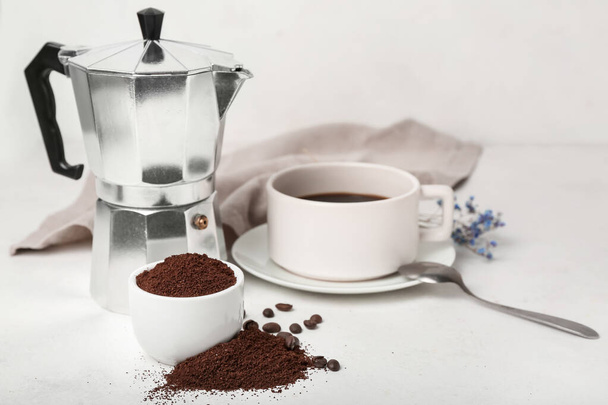 Bowl kahvia jauhe, kuppi ja valmistaja valkoisella pöydällä - Valokuva, kuva