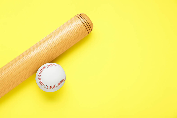 Wooden baseball bat and ball on yellow background, flat lay. Space for text - Фото, изображение