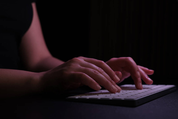 Woman using computer in dark room, closeup. Internet addiction - Fotografie, Obrázek