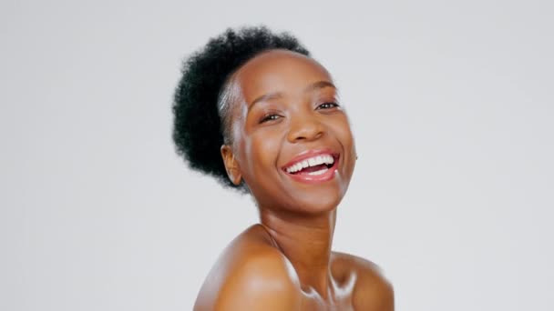 Schoonheid, lachen en portret van een zwarte vrouw met een gloed geïsoleerd op een witte achtergrond. Huidverzorging, glimlach en gezicht van Afrikaans meisje met zelfliefde, stralende behandeling en cosmetische verzorging op de achtergrond. - Video