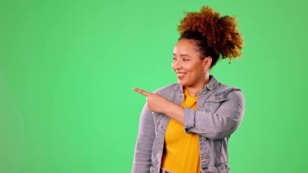 Happy woman pointing to green screen isolated on studio background for product placement, mockup or promotion. Young person or excited model face showing mock up chromakey space for gen z information. - Footage, Video