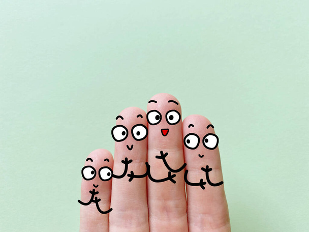 Четыре пальца украшены как четыре человека. Они счастливы.. - Фото, изображение