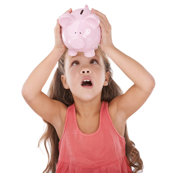 Tasarruf bu günlerde erken başlıyor domuz kumbarasında para arayan sevimli küçük bir kız. - Fotoğraf, Görsel