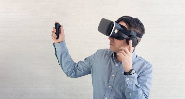 vr voor telefoon en mobiel gamen. man het dragen van virtual reality headset of bril op witte achtergrond, rond te kijken, opgewonden door participatie-effect, kijken naar 3d film, - Foto, afbeelding