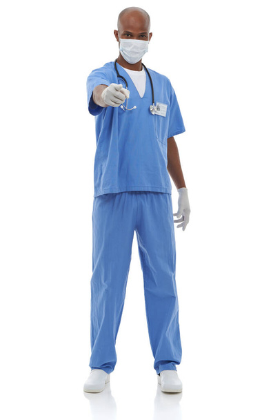 Protégé contre les germes. Prise de vue studio d'un chirurgien portant son équipement de protection et pointant vers la caméra - Photo, image