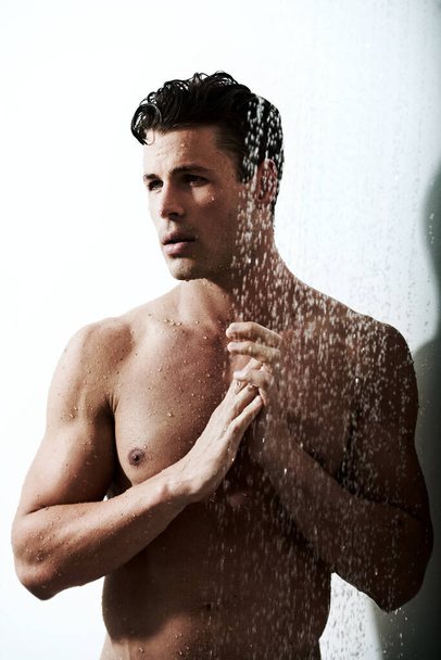 Ducharse le ayuda a pensar con más claridad. un hombre guapo tomando una ducha - Foto, imagen