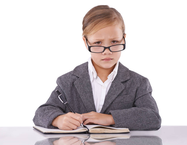Elle veut être une écrivaine célèbre. Une petite fille intelligente regardant sérieusement tout en écrivant dans son carnet de notes - Photo, image