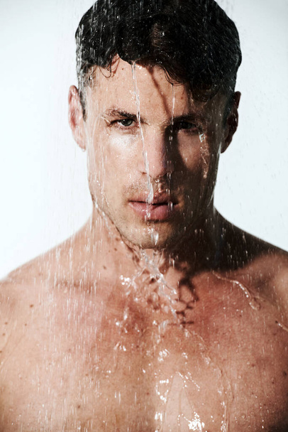 Sprchuju se. Svalnatý mladý muž pod tekoucí vodou sprchy - Fotografie, Obrázek