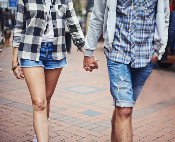 Romantik bir gezinti. Asfaltlı bir sokakta el ele yürüyen bir çiftin kırpılmış görüntüsü. - Fotoğraf, Görsel