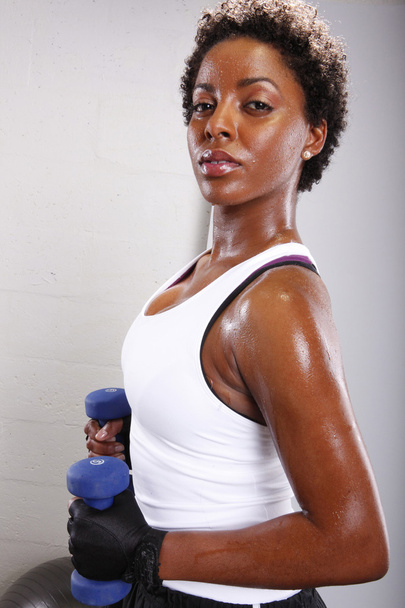 Afro american woman with dumbbells - 写真・画像