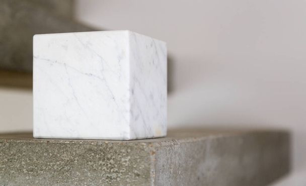 Carrara marble cube on a concrete step block; copy space composition - Φωτογραφία, εικόνα
