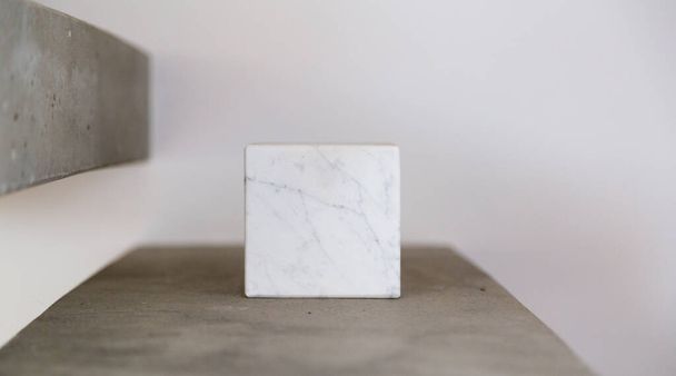 Carrara marble cube on a concrete step block; copy space composition - Фото, изображение