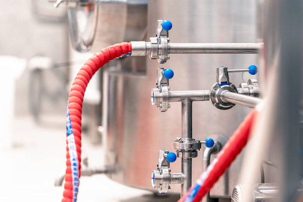 stainless steel boilers and vessels with pipes for brewing beer in a brewery.  - Foto, Imagen