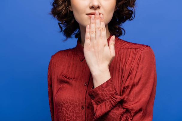vista recortada de la mujer en blusa roja diciendo gracias en el lenguaje de señas aislado en azul - Foto, imagen