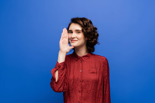 cheerful teacher showing gesture meaning woman or mother on sign language isolated on blue - Photo, Image