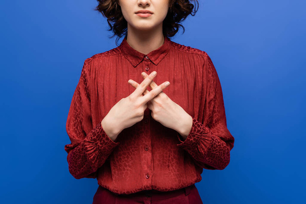 обрезанный вид молодой учительницы жестикулируя при использовании языка жестов изолированы на синий - Фото, изображение