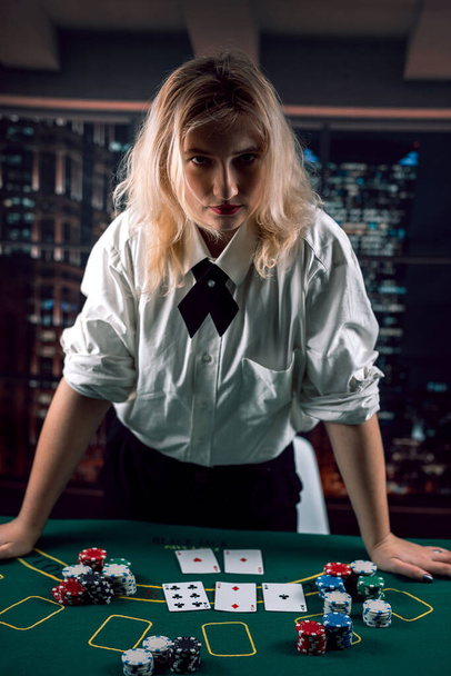 дилер красивая девушка в строгой рубашке с галстуком сдает карты. Казино играет на деньги. Дебют - это женщина - Фото, изображение
