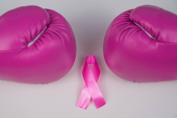 Pink boxing gloves and pink ribbon on a white background. The concept of the fight against breast cancer - Photo, image