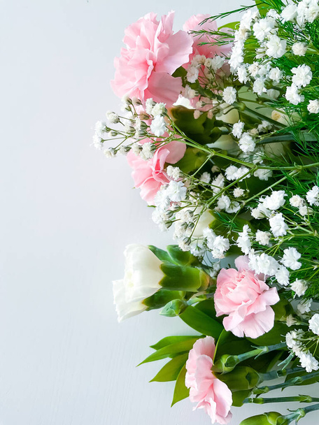 Close up photo of a bouquet of pink and white carnations isolated on a white background. With empty space for text or inscription. For postcard, advertisement or website. - Photo, Image