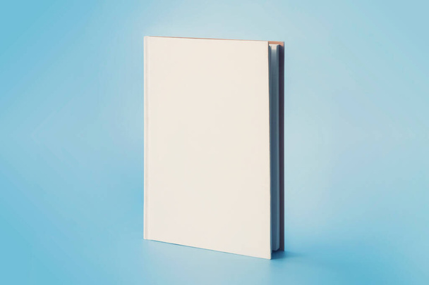 un libro blanco sobre un fondo azul. Espacio vacío en la portada para diseño y texto - Foto, Imagen