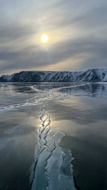 Landscape of Shamanka rock with natural ice breaking in frozen water on Lake Baikal, Siberia, Russia. High quality photo - Φωτογραφία, εικόνα