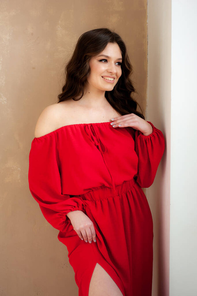 Beautiful smiling woman in long red dress sensual posing - Фото, изображение