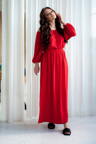 Beautiful smiling woman in long red dress sensual posing - Фото, зображення