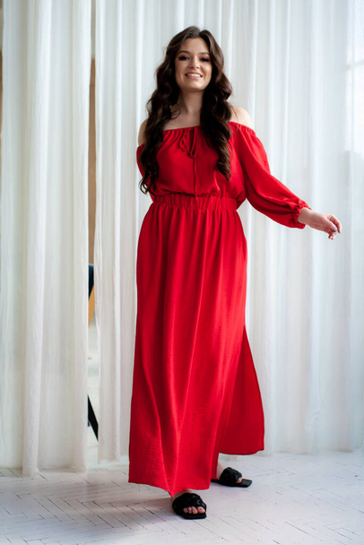 Beautiful smiling woman in long red dress sensual posing - Foto, Imagem
