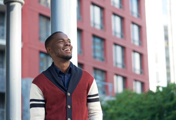 Счастливый черный мужчина улыбается в городе
 - Фото, изображение
