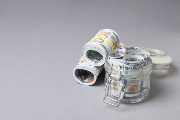 Frasco com notas de dólar no fundo cinza - Foto, Imagem