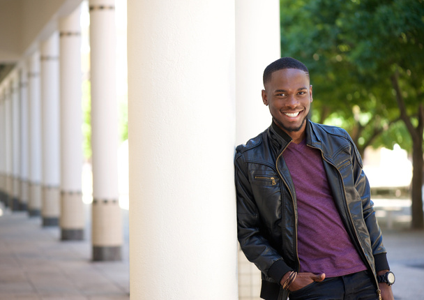 Afro-amerikai fiatalember mosolygott a fekete bőr kabát - Fotó, kép