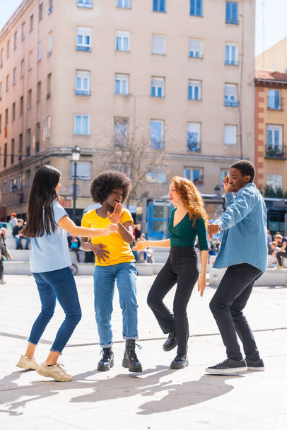 街の広場で踊る多民族の若い友達、楽しみを持つグループダンサー - 写真・画像