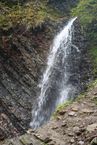 Pequeña cascada y pliegues geológicos de montaña en las montañas. Cascada de Zhenetskyi Huk o la cascada de Huk, río Zhenets, Parque Nacional de los Cárpatos, cordillera montañosa Gorgany, oeste de Ucrania - Foto, imagen