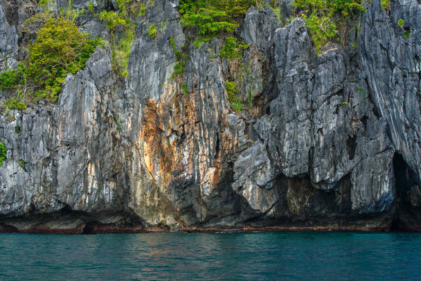 To zdjęcie pokazuje oszałamiająco wytrzymałe wybrzeże Filipin. Seria skalistych wychodni, noszonych gładko przez fale okrążające, rozciąga się na horyzont, podczas gdy turkusowe morze wiruje wokół nich. - Zdjęcie, obraz