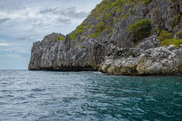 Ez a fotó a Fülöp-szigetek elképesztően zord partvonalát mutatja be. Egy sor sziklás kiugrás, melyet a hullámok elkoptatnak, kinyúlik a horizontig, miközben a türkiz tenger örvénylik körülöttük.. - Fotó, kép
