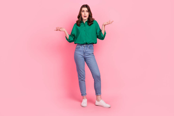Full length photo of impressed shocked woman wear green shirt open mouth rising arms isolated pink color background. - 写真・画像