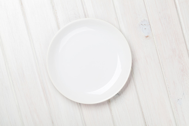 Пустая тарелка на деревянном столе
 - Фото, изображение