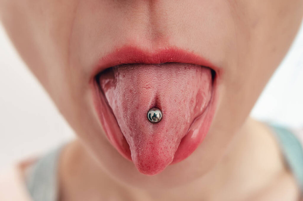 A língua da mulher com piercing. Salão de Cosmetologia, boca feminina aberta close-up. - Fotografia, imagem