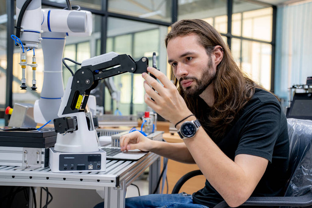 Robotic Arm engineer check on equipment in its with software of an Artificial Intelligence Computer Processor Unit. - Photo, Image