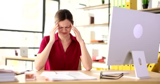 Atrakcyjna kobieta przy biurku masująca świątynie na bóle głowy. Napięcie ból głowy powoduje i objawy - Materiał filmowy, wideo