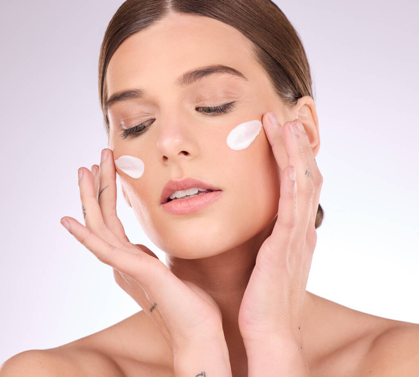 Beauty, skincare or girl with face cream product in daily grooming treatment with makeup cosmetics in studio. Dermatology, mockup space background or female model applying facial sunscreen lotion. - Photo, image