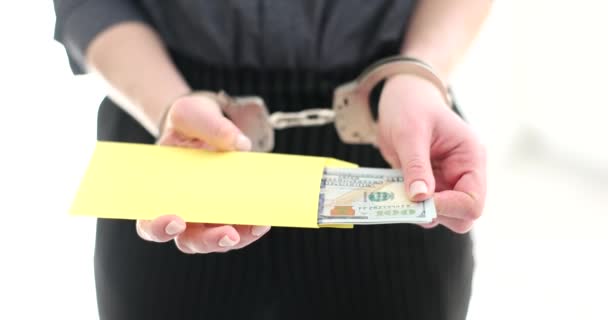 Доктор в наручниках со взяткой в конверте на рабочем месте. Коррупция и финансовые преступления и закон - Кадры, видео
