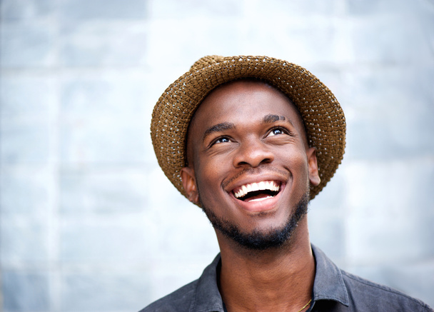 Cheerful young man laughing and looking up - Foto, imagen