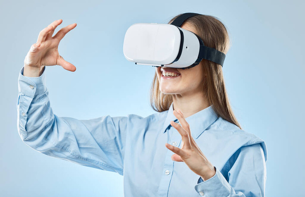 Zakelijk, futuristisch en vrouw met virtual reality bril, metaverse en online leren tegen een blauwe studio achtergrond. Vrouwelijke werknemer, ondernemer en dame met vr, futuristisch en innovatie. - Foto, afbeelding