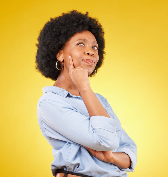 Thinking, confused and black woman in studio pensive, puzzled and uncertain on yellow background. Doubt, contemplate and emoji by unsure female with decision, choice or option on isolated space. - Foto, Imagem