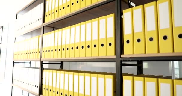 Identical yellow folders on shelf in archive. Work with documents and database storage - Footage, Video