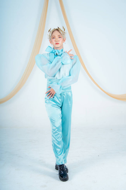 an Asian woman posing elegantly in a blue costume in a white room - Foto, afbeelding