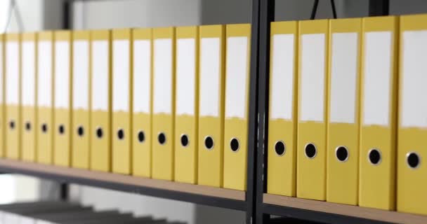 Gele mappen van kantoordocumenten staan in rij op de plank. Bedrijfsdocument en documentatie archief - Video