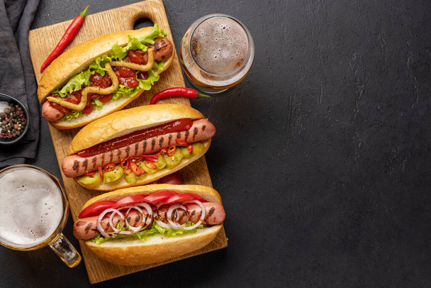 Various hot dog and beer. Homemade hotdogs on cutting board. Flat lay with copy space - Fotó, kép
