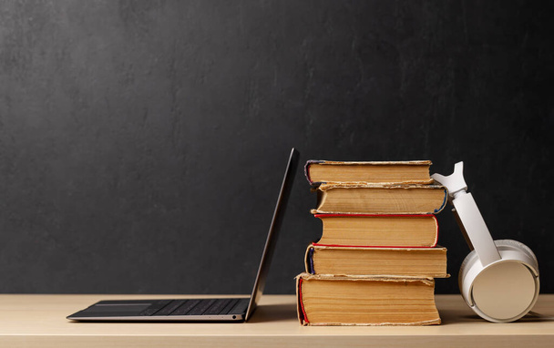 Laptop and stack of old books. With space for your text. Learn and work concept - Foto, Imagen